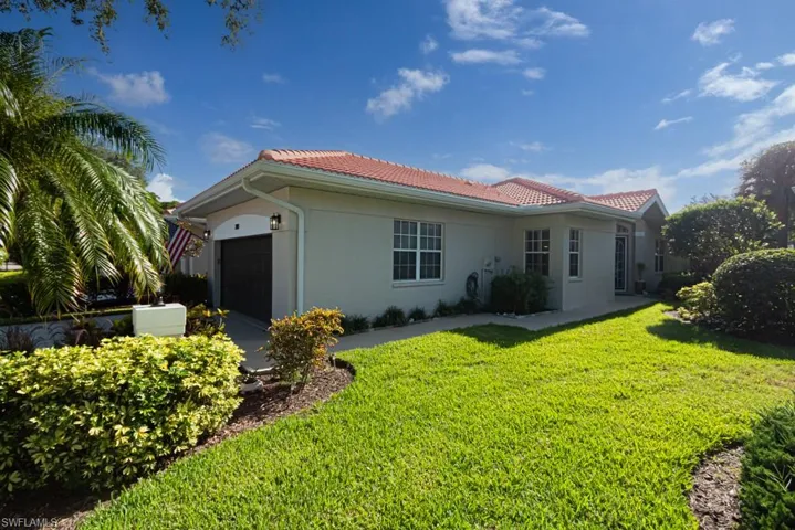 View of front of property featuring a garage and a front lawn