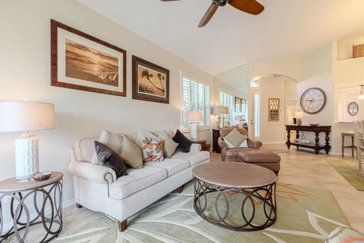 Living room featuring tile patterned floors and ceiling fan