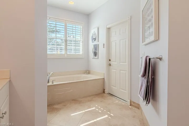 Bathroom with vanity, tile patterned flooring, and a bathing tub