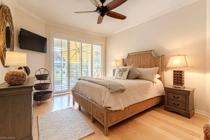 Bedroom with access to exterior, ceiling fan, hardwood / wood-style flooring, and ornamental molding
