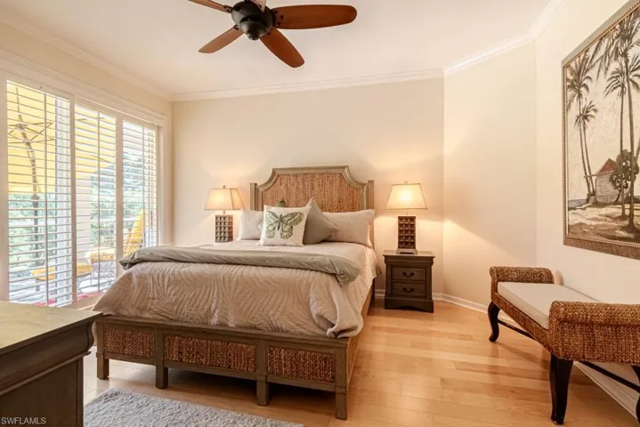 Bedroom featuring ceiling fan, light hardwood / wood-style flooring, and ornamental molding