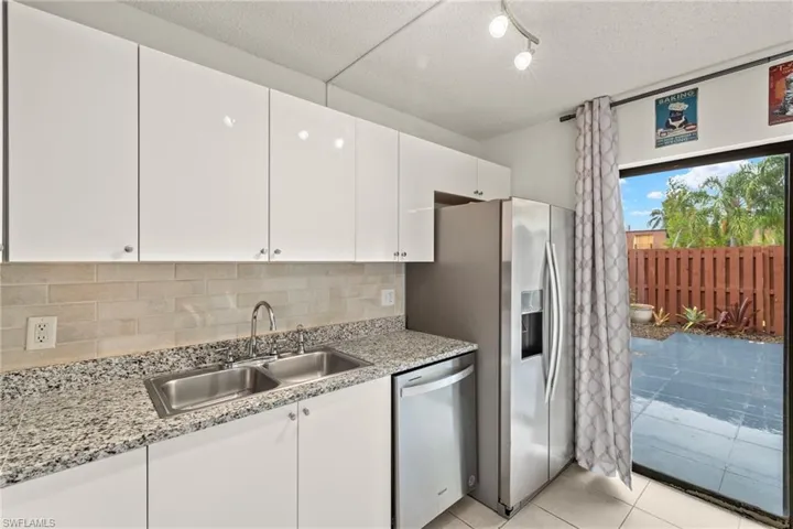 Modern kitchen featuring white cabinetry and light-toned backsplash