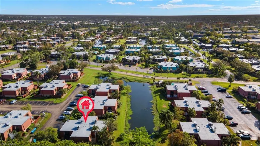 Aerial perspective showcasing a community with multiple residential buildings featuring red brick exteriors and light-colored roofs