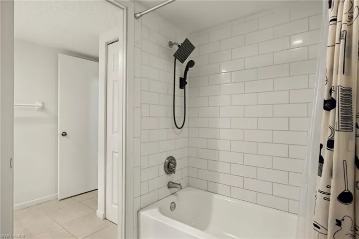 Bathtub with white subway tile surround and matte black shower fixtures