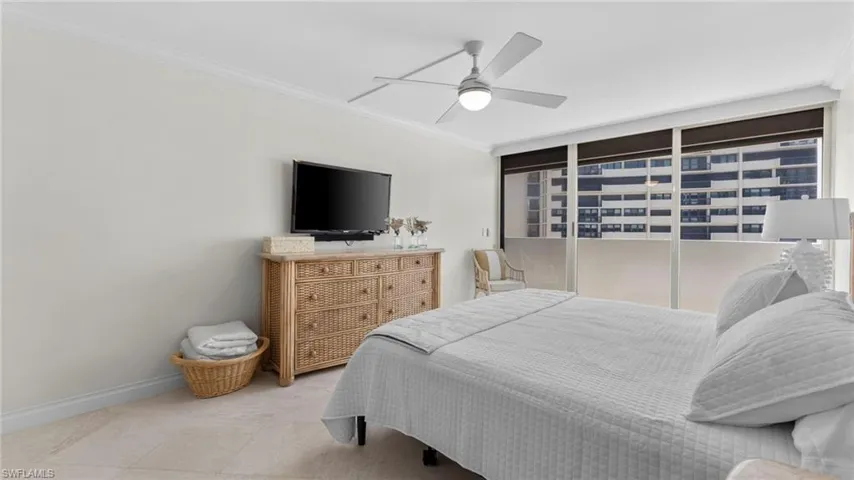 Bedroom with tile patterned flooring, ceiling fan, and crown molding