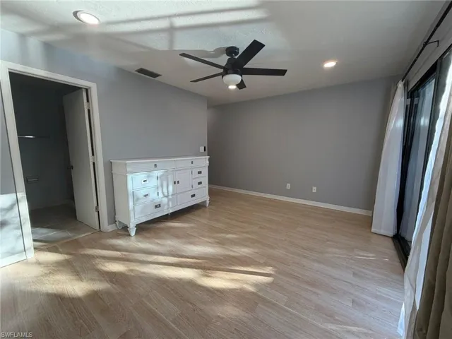 Unfurnished bedroom with light wood-style floors, a ceiling fan, recessed lighting, and ensuite bathroom