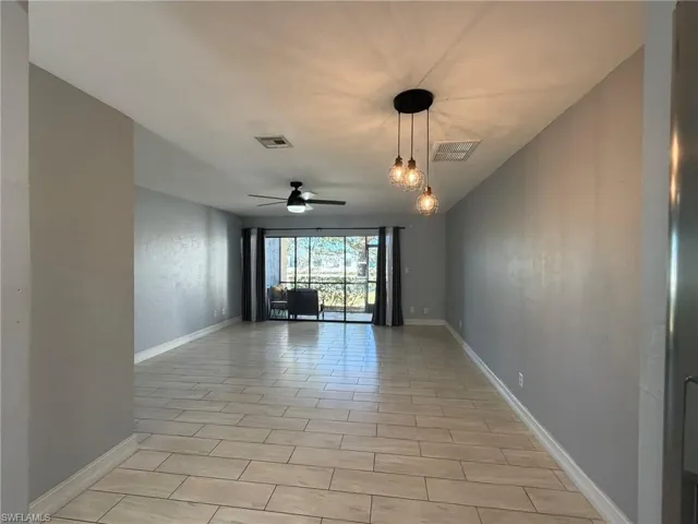 Empty room featuring ceiling fan and baseboards