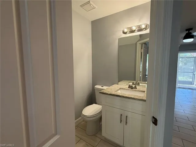 Half bathroom featuring vanity and light tile patterned flooring