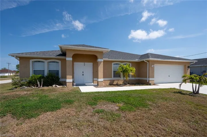 Ranch-style home with a garage and a front yard -1001 NE 39th Ter