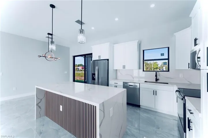 Kitchen with appliances with stainless steel finishes, white cabinetry, plenty of natural light, and recessed lighting