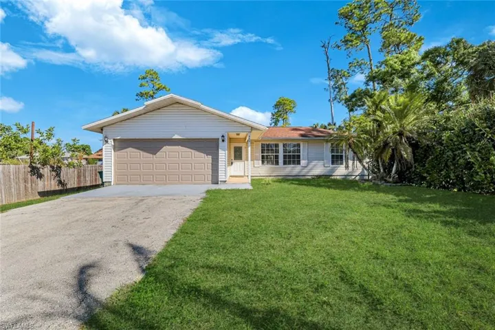 Ranch-style home with concrete driveway and an attached garage