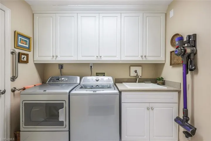 Laundry area featuring cabinets, independent washer and dryer, and sink