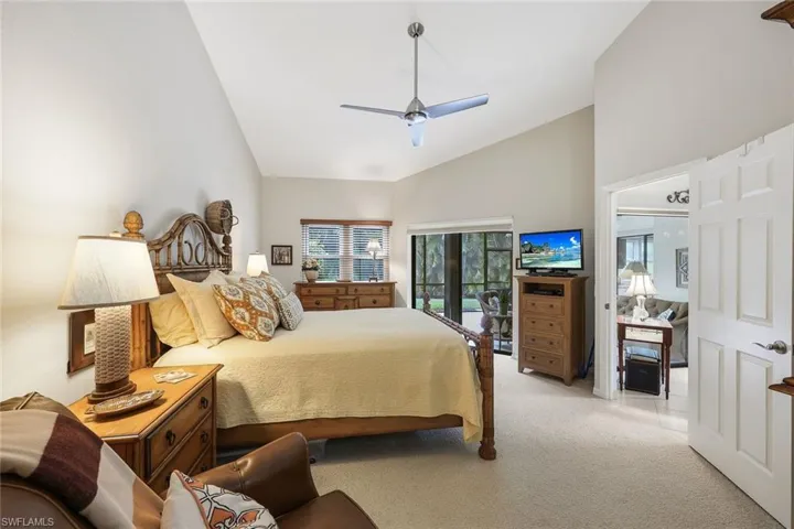 Carpeted bedroom featuring high vaulted ceiling and ceiling fan