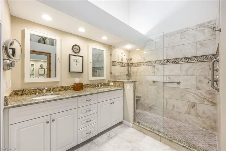 Bathroom featuring vanity, tile patterned floors, and a shower with shower door