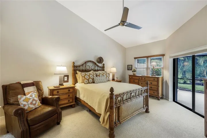 Bedroom with access to exterior, light carpet, high vaulted ceiling, and ceiling fan