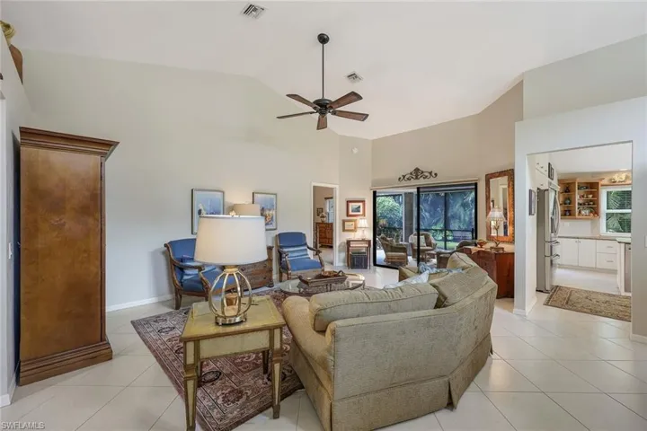 Living room featuring ceiling fan, high vaulted ceiling, and light tile patterned flooring