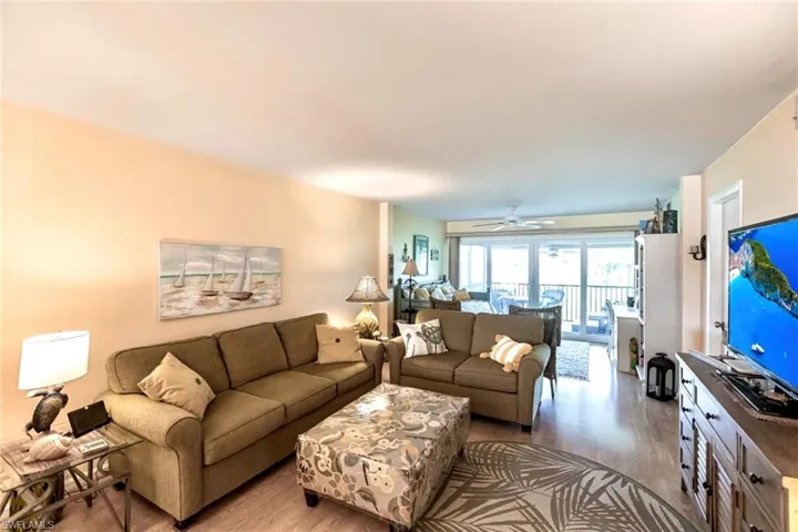 Living area has an easy living floorplan with indoor outdoor flow to the screened lanai with expansive golf course views