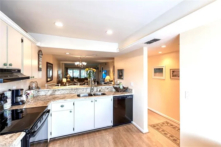 Bright kitchen offers  plentiful cabinet storage, recessed lighting, bartop for dining