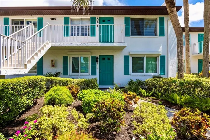 Front view of upper condo framed with palm trees, assigned parking