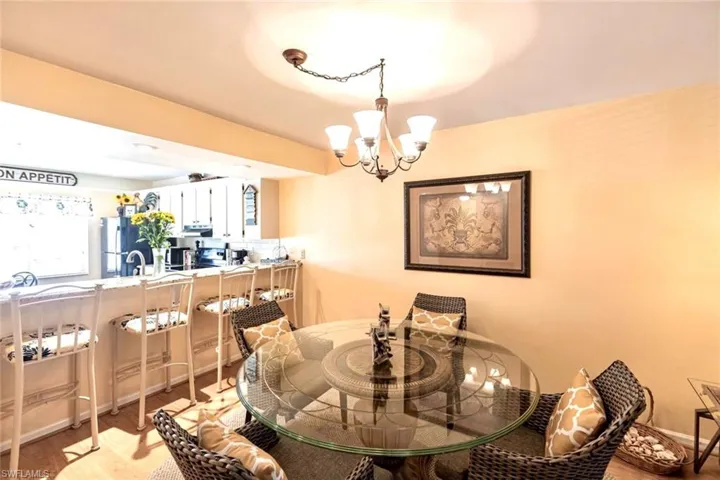 Dining area with a chandelier above dining table, and bartop seating