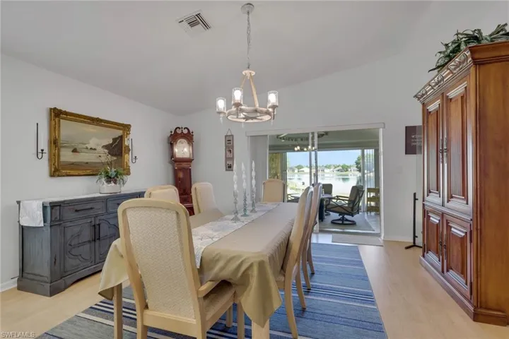 Dining room with hanging lights, light wood finished floors, and a water view