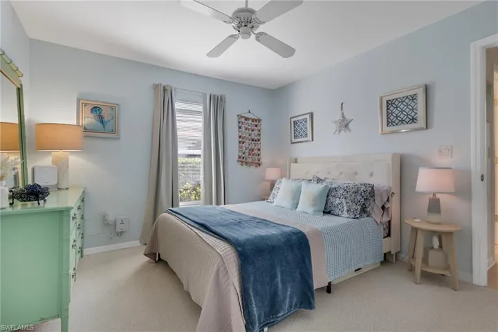 Bedroom with a ceiling fan and light carpet