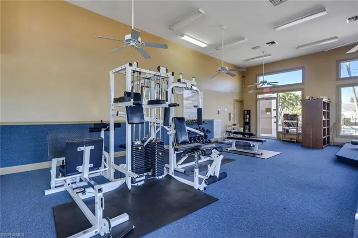 Exercise room featuring a high ceiling and a ceiling fan