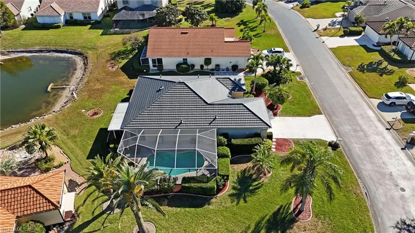 Aerial perspective of suburban area featuring a large body of water and a pool area