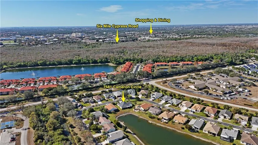 Aerial view of property and surrounding area featuring a nearby body of water and nearby suburban area