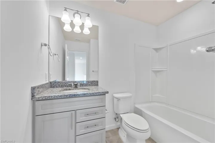 Bathroom with shower / tub combination, vanity, light tile patterned floors, recessed lighting, and a chandelier