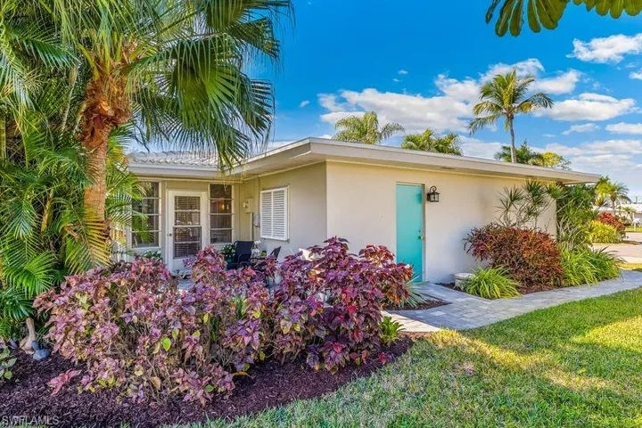 Beautiful patio/sitting area with lush landscaping on the rear of the home with access to the sun/family room and new pavers with a walkway to the exterior garage side-door and front of the home.