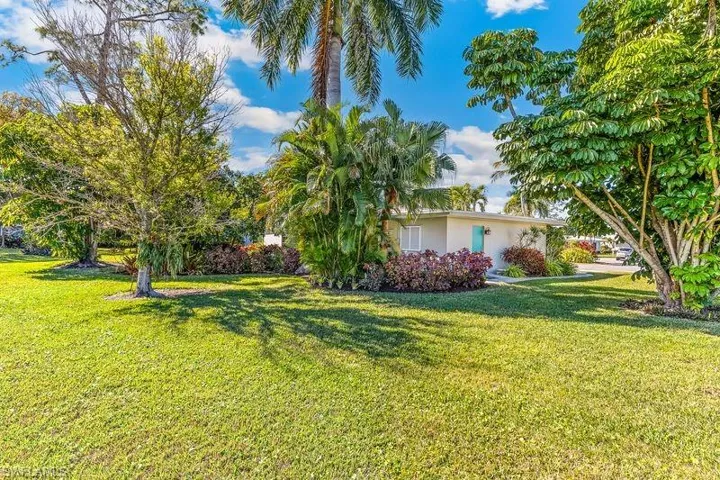 View of rear of the home showing the mature and lush landscaping as well as the privacy on the rear of the property.