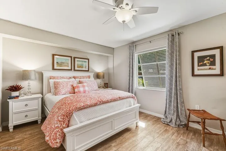 Lovely Primary Bedroom with tiled wood-look finished flooring, ceiling fan, and an updated ensuite master bath with large walk-in shower.