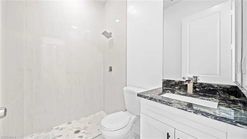 Full bathroom with tiled shower and vanity