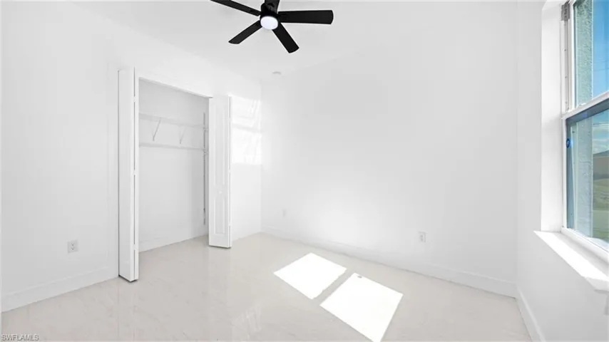 Unfurnished bedroom with a ceiling fan and a closet