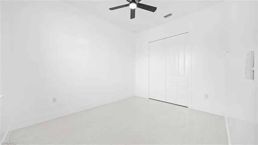 Unfurnished bedroom with a ceiling fan and a closet