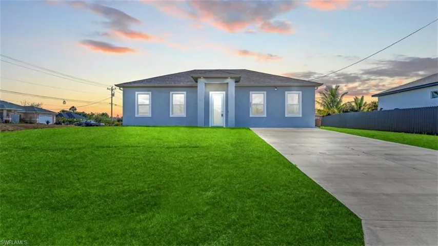 View of front facade featuring stucco siding, concrete driveway, and a shingled roof