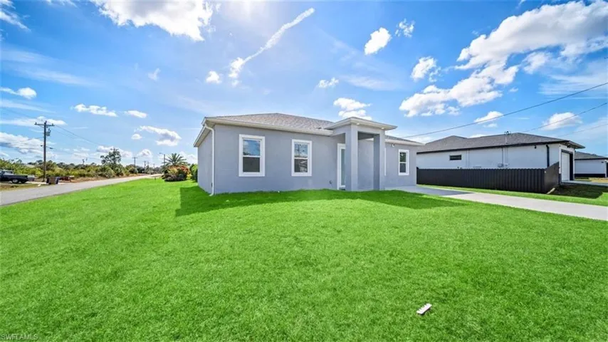 View of front of home with a front lawn, stucco siding, and concrete driveway