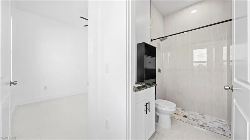 Bathroom featuring a tile shower and vanity