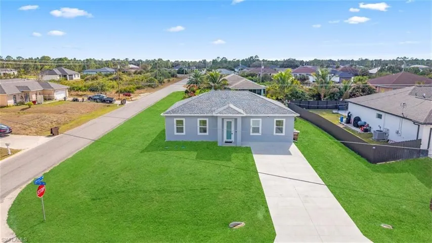 View of front facade with a residential view, driveway, and stucco siding