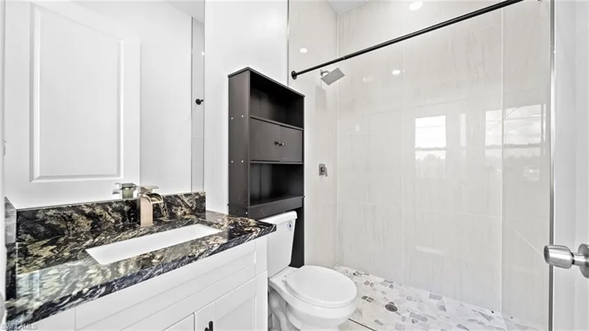 Bathroom featuring a shower stall and vanity