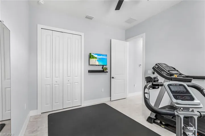 Exercise area featuring baseboards and ceiling fan