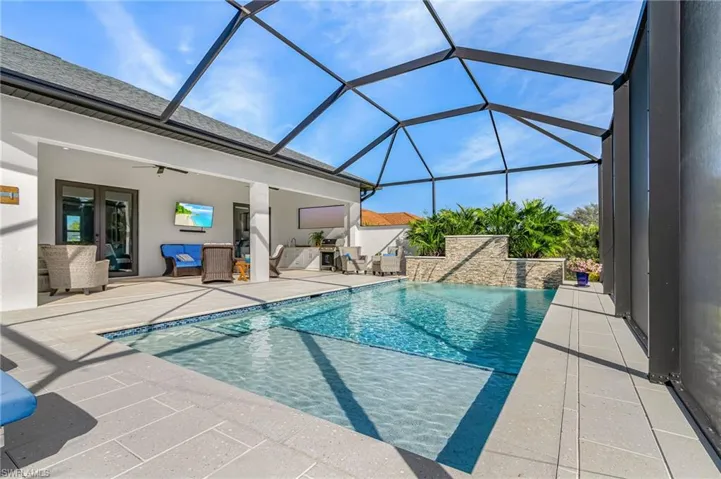 Swimming pool featuring a patio area, a sunroom, glass enclosure, and french doors