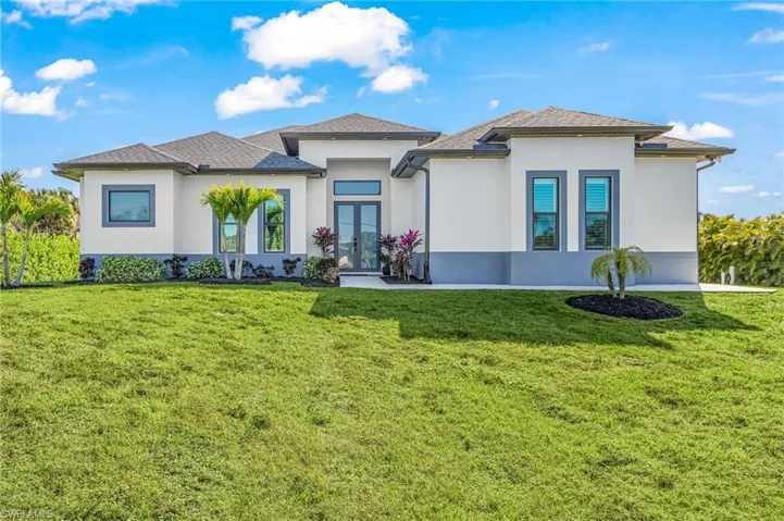 Prairie-style home with french doors, stucco siding, and a front lawn