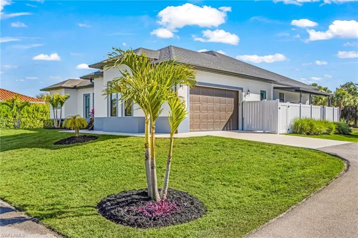 Ranch-style home with driveway, stucco siding, a garage, and roof with shingles