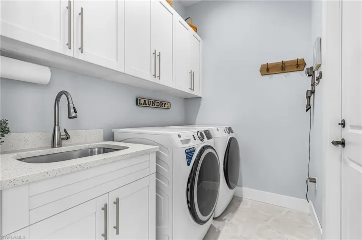 Washroom featuring washing machine and clothes dryer and cabinet space