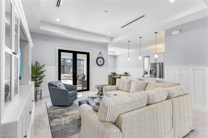 Living area featuring wainscoting, a decorative wall, and a tray ceiling