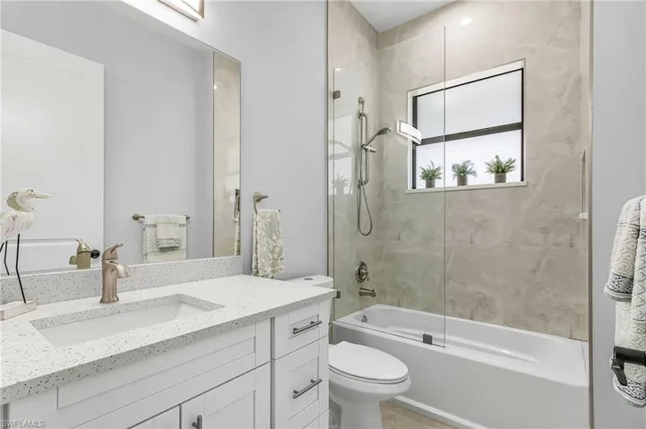 Bathroom featuring enclosed tub / shower combo and vanity