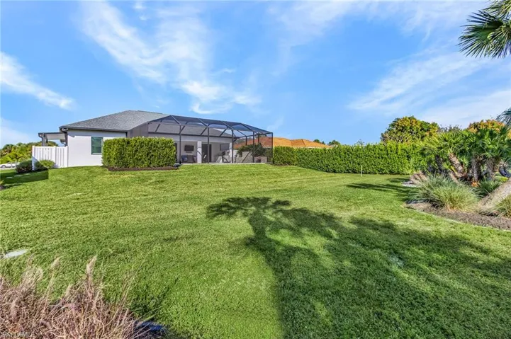 View of yard featuring a sunroom and glass enclosure