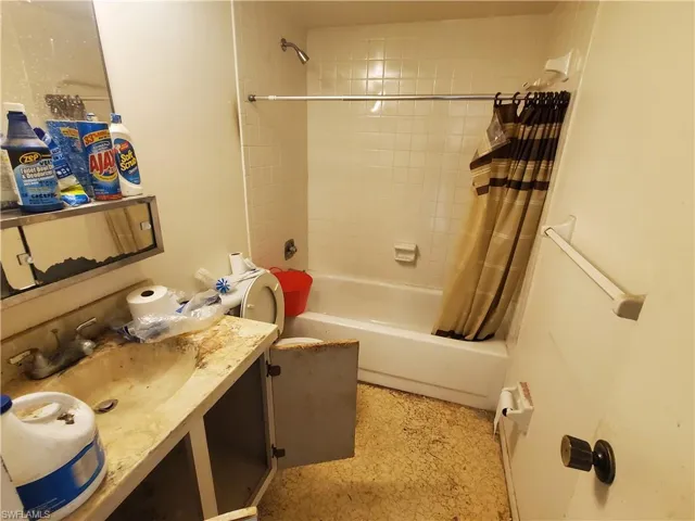 Bathroom with vanity and shower / bath combination with curtain